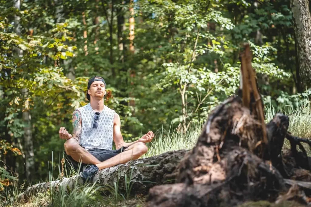 A teenager is sitting quietly with his eyes closed and calming himself down knowing it as an important self-care activity