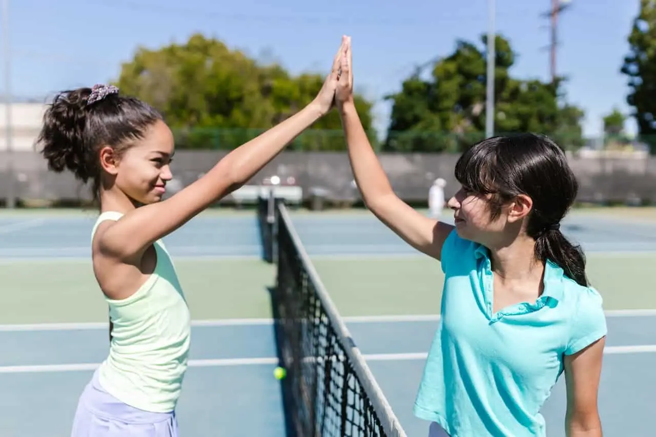 Photo of two smiling teenagers shaking hands, symbolizing successful conflict resolution activities for teens