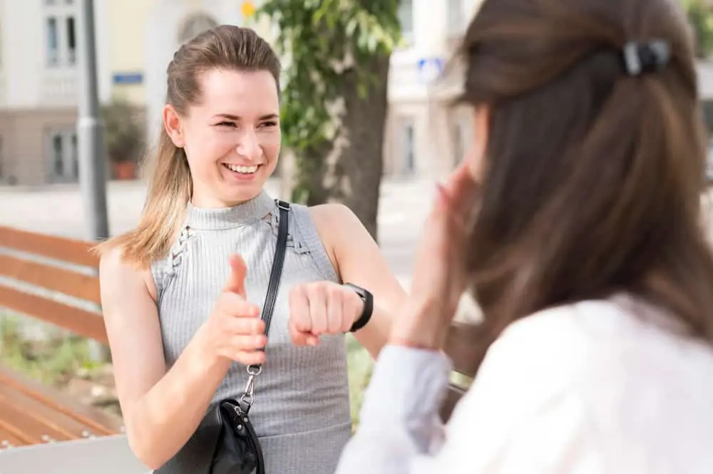  two teens communicating silently, using hand gestures and body language