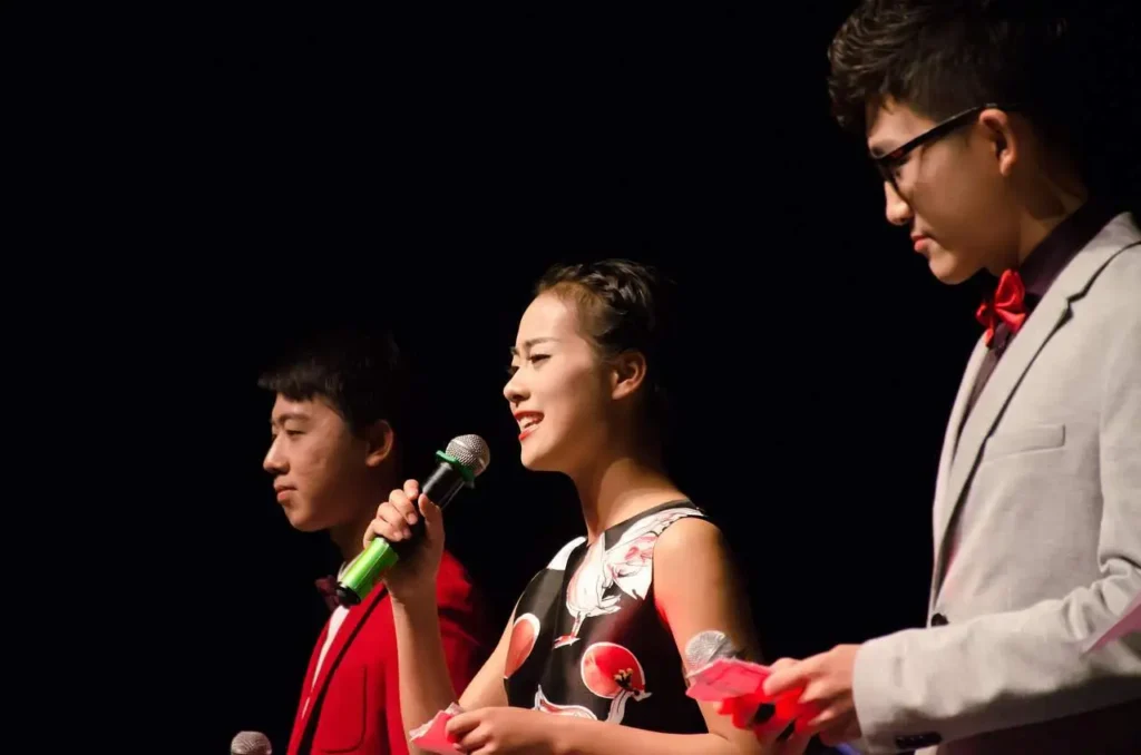 A teen girl speaking in front of an audience with confident body language, as speaking in public is one of the best communication activities for teens