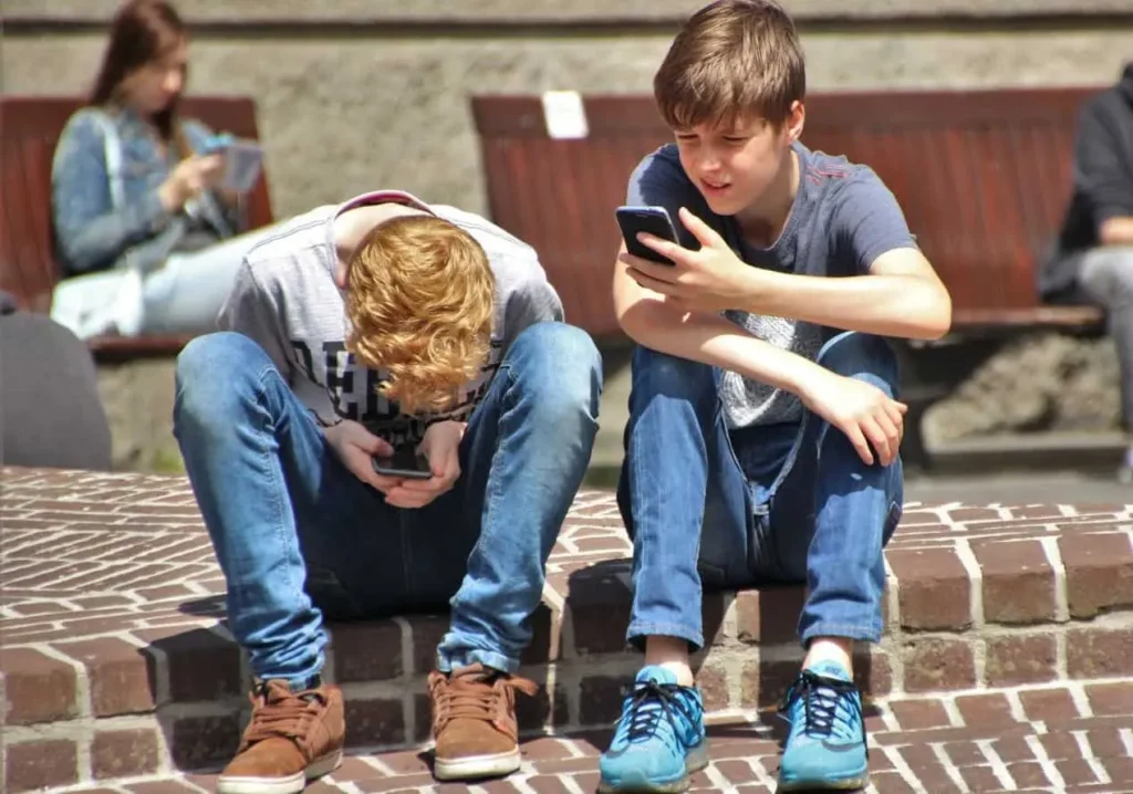 Two boys, lost in mobiles and unaware of the world. Which is likely to affect their in-person communication skills