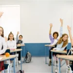 Kids in the class raising their hands and actively participating in morning meeting sharing ideas