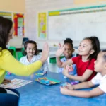 A teacher with her students extending their hands for a high-five greeting in morning meeting